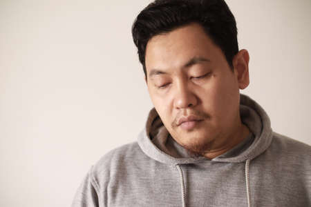 Sad depressed anxiety Asian man thinking contemplating bad thing happened in his life, stress exhausted feeling down expression, financial or relationship problem conceptの写真素材