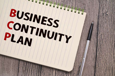 Business continuity plan, text words typography written on book against wooden background, life and business motivational inspirational conceptの写真素材