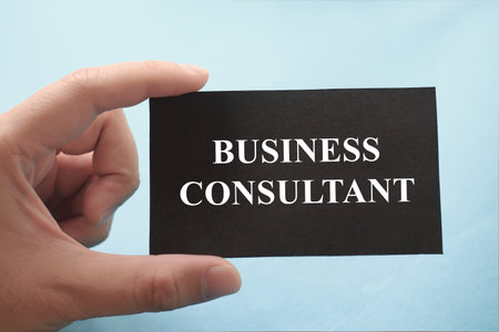 Business consultant, text words typography written on paper against blue background, life and business motivational inspirational conceptの写真素材