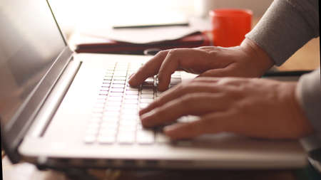 Close up of person fingers typing on laptop, business or education conceptの写真素材