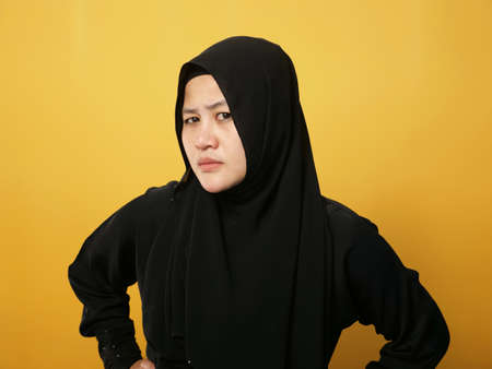 Portrait of cynical Asian muslim woman with suspicious expression looking and starring, mistrust misdoubt conceptの写真素材