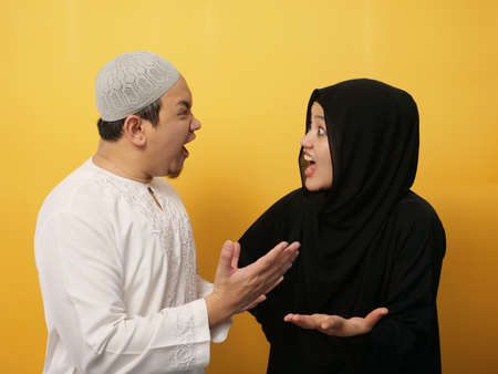 Asian muslim couple husband and wife having fight, argue and screaming on each other, bad relationship in marriage conceptの写真素材