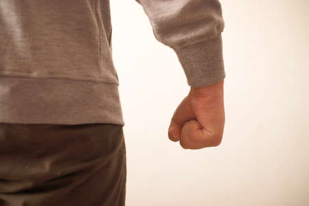 Angry person conceptual, clasped hands close up, ready to fight or punch, anonymous person over...