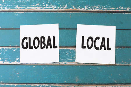 Global and Local, text words typography written on paper against wooden background, life and business motivational inspirational conceptの写真素材