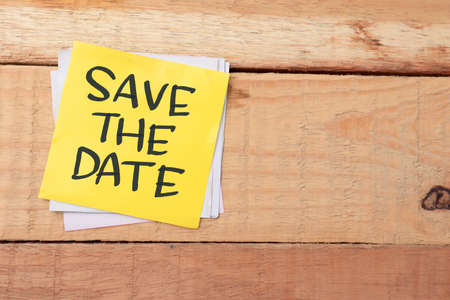 Save the date, text words typography written on paper against wooden background, life and business motivational inspirational conceptの写真素材