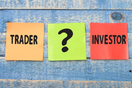 Trader or investor, text words typography written on paper against wooden background, life and business motivational inspirational conceptの写真素材