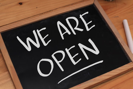 We are open, text words typography written on chalkboard against wooden background, life and business motivational inspirational conceptの写真素材