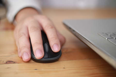 Hand using computer mouse, clicking pointer laptop pc peripheral, close up