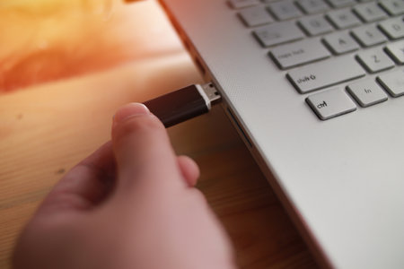 Person inserting plug in flashdisk into usb port in laptop personal computer, data transfer device...