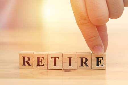 Retire, businessman arrange text words typography written on wooden block, life and business motivational inspirational conceptの写真素材