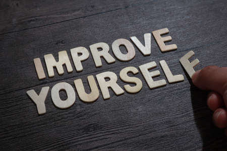 Improve yourself, text words typography written with wooden letter on black background, life and business motivational inspirational conceptの写真素材