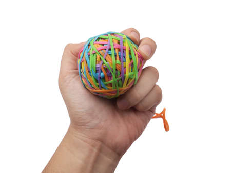 Hand holding colorful multi color elastic rubber bands ball isolated on white backgroundの写真素材