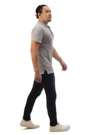 Asian man wearing grey shirt black denim and white shoes, walking forward, side view, happy confidence expression. Full body portrait isolated cut outの写真素材