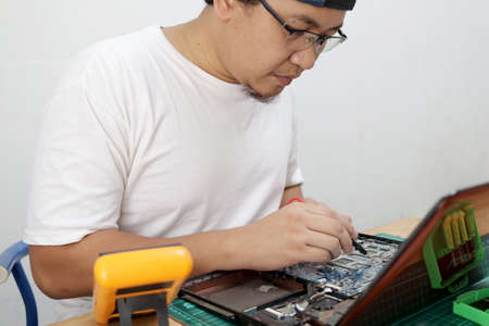 Close up of technician engineer trying to repairing broken laptop. Computer repairs and upgrade conceptの写真素材