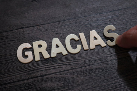 Gracias, thank you in spanish, text words typography written with wooden letter on black background, life and business motivational inspirational conceptの写真素材