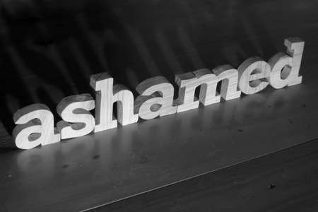 Ashamed, text words typography written with wooden letter on black background, life and business negativity conceptの写真素材