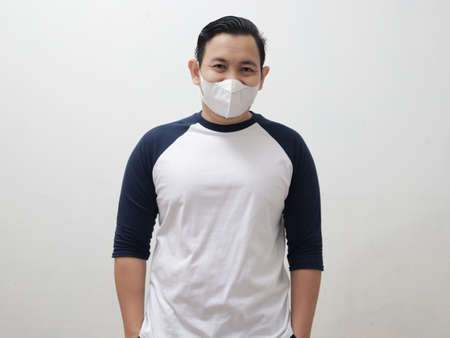 Happy Asian man wearing protective facial mask smiling to camera, new normal life conceptの写真素材