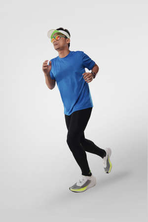 Athletic male person running in run sport clothes, full length studio portrait over white backgroundの写真素材
