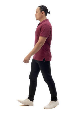 Asian man wearing casual maroon red shirt black denim and white shoes, walking forward, side view, happy confidence expression. Full body portrait isolated cut outの写真素材