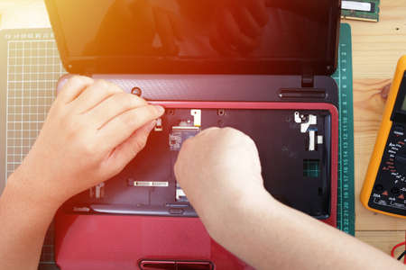 Close up of technician engineer trying to repairing broken laptop. Computer repairs and upgrade...