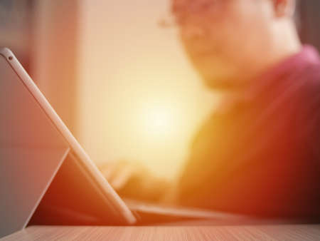 Young man typing on his tablet laptop, businessman freelancer working at home or cozy cafe, focus on...