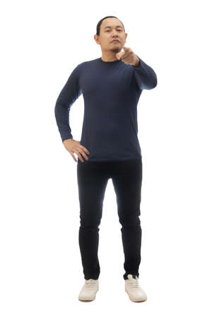 Young Asian man pointing to camera with cynical expression, giving warn. Full body portrait isolated on whiteの写真素材