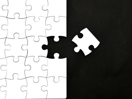 White jigsaw puzzle on black background, top angle view layoutの写真素材