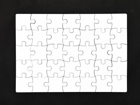White jigsaw puzzle on black background, top angle view layoutの写真素材