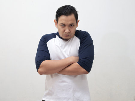 Asian man looked angry and shows critical attitude, crossed arms on chest with unhappy expressionの写真素材