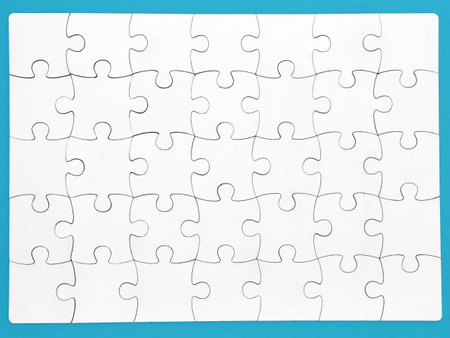 White jigsaw puzzle on blue background, top angle view layoutの写真素材