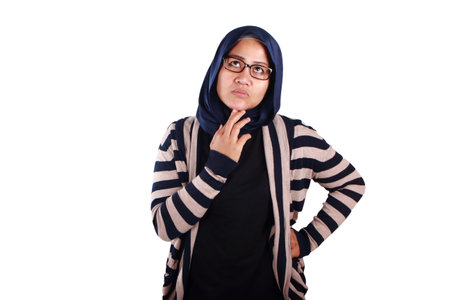 Asian muslim woman wearing hijab shows thinking contemplating expression. Looking for solution of a problem. Close up portrait isolated on whiteの写真素材