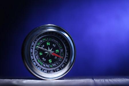 Close up of magnetic silver metal compass on dark blue backgroundの写真素材