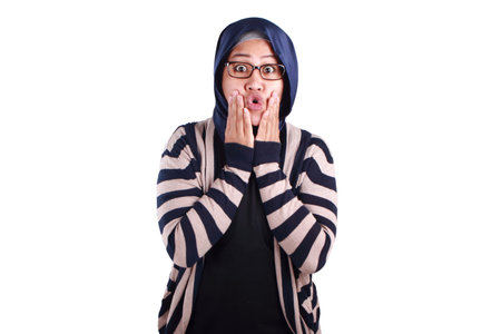 Asian muslim lady wearing hijab shows surprised or shocked expression with open mouth, close up facial expression, isolated on whiteの写真素材