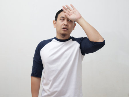 Young Asian man gets cold and fever, feeling headache pain deezy and shiver, against grey backgroundの写真素材