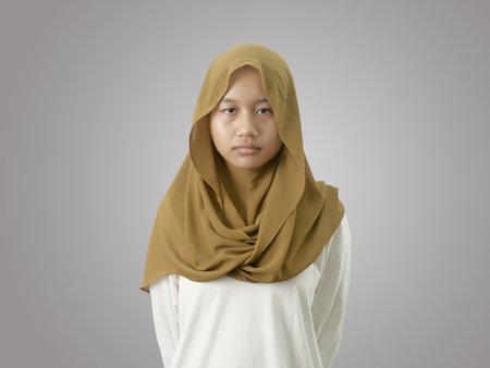Portrait of sad muslim teenage girl looking at camera with empty lookの写真素材
