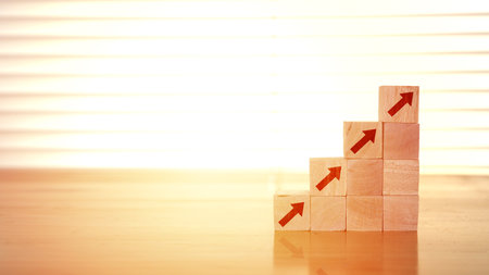 Growth concept, arrow icon on wooden blocks arranged as stairway to the top direction, moving upの写真素材