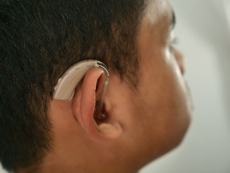 Portrait of Asian boy wearing hearing aid device, close upの写真素材