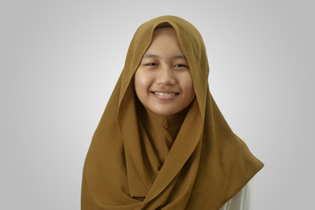Asian Muslim Teenage Girl Wearing Hijab Smiling while looking at Cameraの写真素材