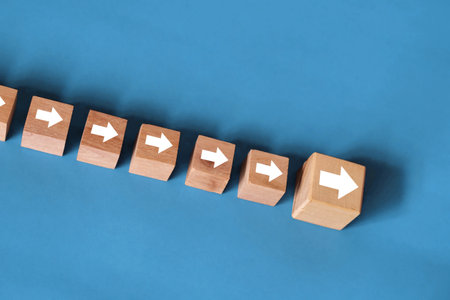 Leadership concept, front leader followed by others, wooden block with arrow directional symbolの写真素材