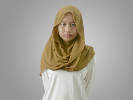 Portrait of sad muslim teenage girl looking at camera with empty lookの写真素材