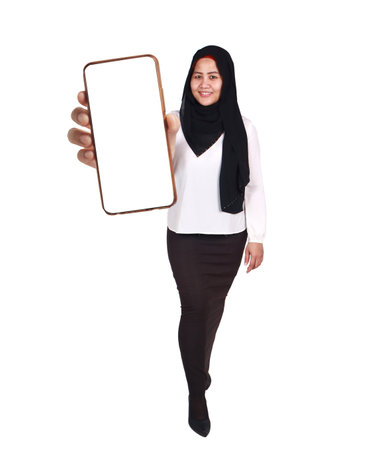 Young Asian muslim woman wearing hijab looking to camera, smiling and showing empty blank white copy space phone mock up templateの写真素材