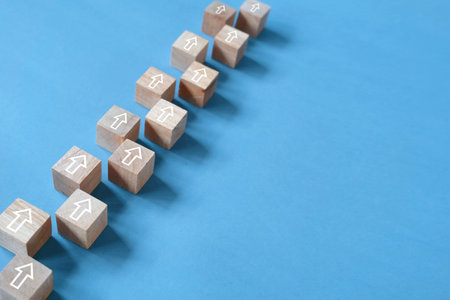 Step by step keep forward concept, arrow direction, wooden block on blue backgroundの写真素材