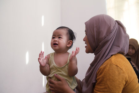 Asian muslim mother takes care of her child, mom put shirt on baby girl after bathing