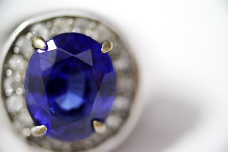 Vintage antique silver ring with blue sapphire gemstone on it, worn rusted look, blurred background