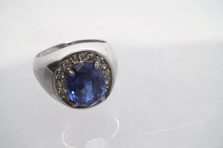 Vintage antique silver ring with blue sapphire gemstone on it, worn look, over white backgroundの写真素材