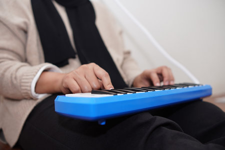 Anonymous woman playing pianica, melodica blow organ musical intrumentの写真素材
