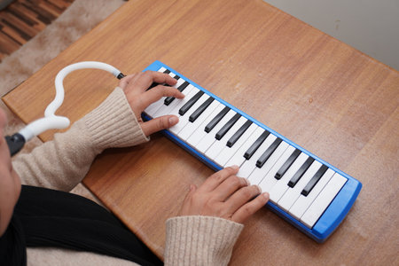 Anonymous woman playing pianica, melodica blow organ musical intrument