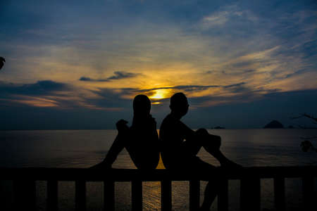 Silhouette of couple watching sunset.soft focus due to silhoutte.visible noise due to high iso
