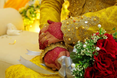 Bride's hand, image of mehendi henna pattern. Short manicure nails. Beautiful composition, fabric background banner. Round mandala abstract flowers, flowers lilac. Close up professional art photoの写真素材