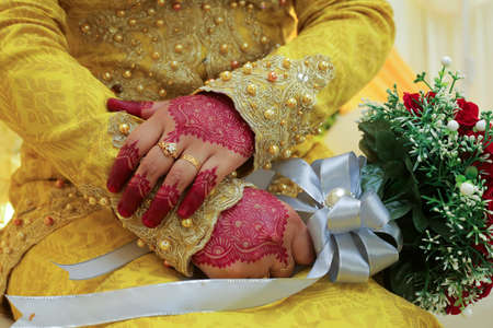 Bride's hand, image of mehendi henna pattern. Short manicure nails. Beautiful composition, fabric background banner. Round mandala abstract flowers, flowers lilac. Close up professional art photoの写真素材